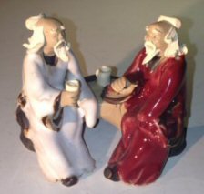 Ceramic Figurine<br>Two Men Sitting On A Bench<br>Color: White & Red